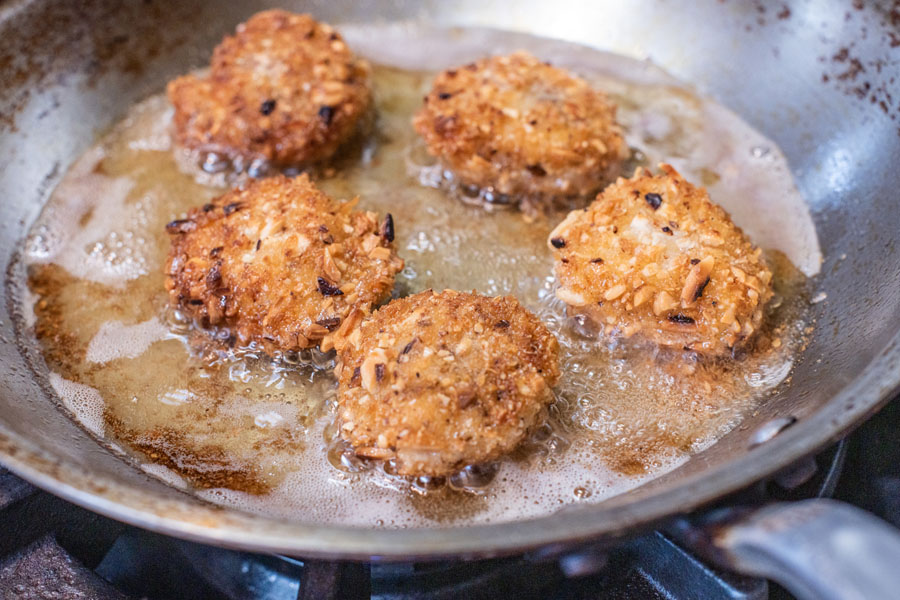 Pan frying almond panko crusted Lighthouse Seafoods sea scallops in butter until golden brown.