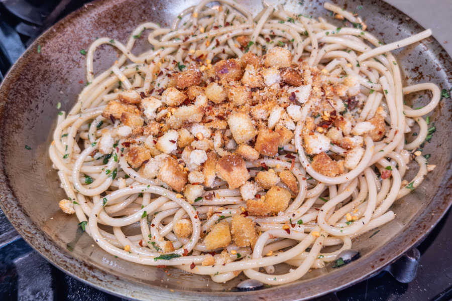 Spaghetti for Scallops alla Siciliana with toasted breadcrumbs cooking in pan for a Lighthouse Seafoods recipe.