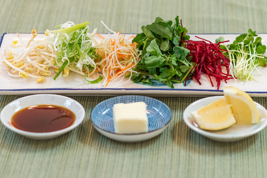 Ingredients for Lighthouse Seafoods seared bay scallop salad including bean sprouts, shredded carrots, greens, beetroot, sauce, butter, and lemon.