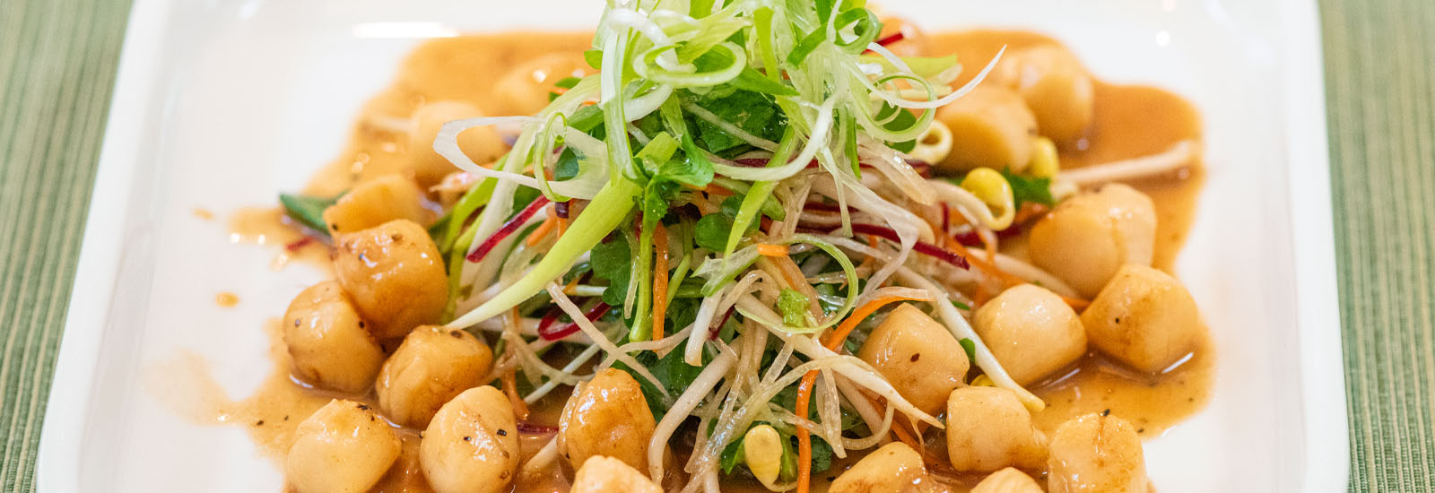 Lighthouse Seafoods seared bay scallop salad with shredded vegetables and savory dressing.
